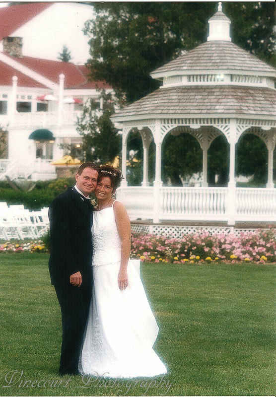 Bride and Groom pose for picture by a Gazebo